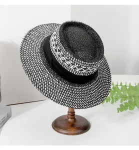 Detailed view of a chic black and white woven straw hat with a black ribbon band.
