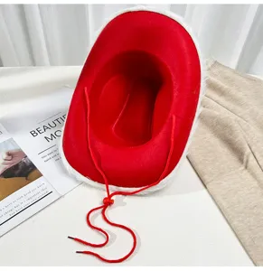 Vista dettagliata del cappello da cowboy di Natale rosso con bordo in peluche bianco e sottogola.