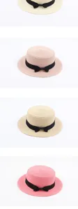 Detailed view of the vintage flat top straw hat with a black bow, perfect for sunny beach days.