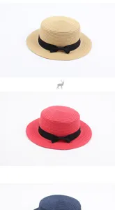 Detail view of British vintage flat-top straw hat with black bow, simple sunshade beach hat.