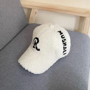 Detail shot of a white fluffy teddy fleece baseball cap with black embroidered letters and cozy texture.