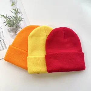 Close up of colorful knit beanie hats detail, soft acrylic winter warm caps display view.