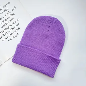 Close up of a cozy purple knit beanie hat, showing soft wool texture and rolled cuff detail.