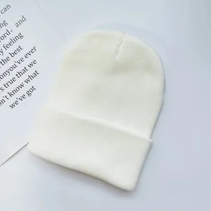 Plain white knitted beanie hat, warm pull-on winter cold cap for adults, minimal style detail.