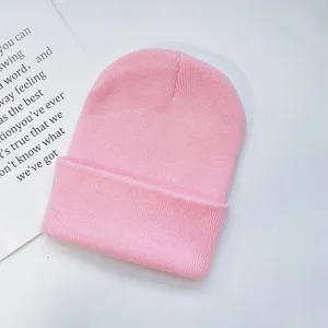 Close-up detail of plain pink knit beanie hat, soft knitted fabric, minimalist cold hat style.