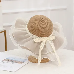 Detail shot of a women's straw sun hat featuring a wide mesh brim and delicate lace ribbon bow.