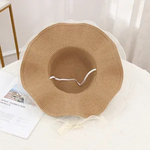 Detailed view of women straw sun hat with white mesh lace ribbon and windproof rope for beach.