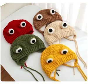 Detailed view of cute handmade crochet frog baby earflap hats with warm fleece lining.
