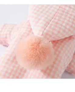 Nahaufnahme von rosa kariertem Hunde-Wintermantel flauschigem Bommel Haustierbekleidung.