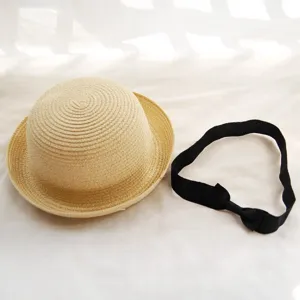 Straw woven dome sun hat with black bow detail, perfect outdoor beach accessory for summer.