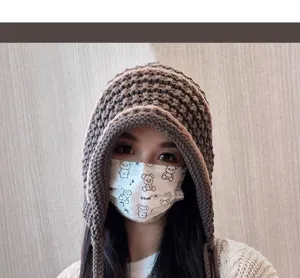 Close-up of cozy brown knit earflap beanie hat with long tassels, perfect for winter style.