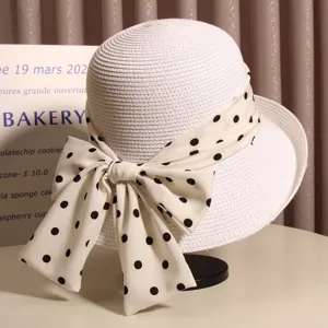 Women's summer straw bucket hat with elegant polka dot bow, chic rolled brim sun protection cap.