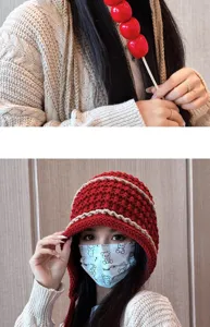 Handmade knitted beanie hat with tassels and ear flaps, cozy winter headwear detail shot.