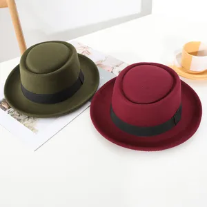 Close-up detail of stylish wool felt pork pie hats in army green and burgundy colors.