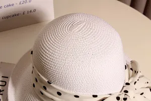Detailed view of women summer straw hat with chic polka dot bow and woven texture beach.