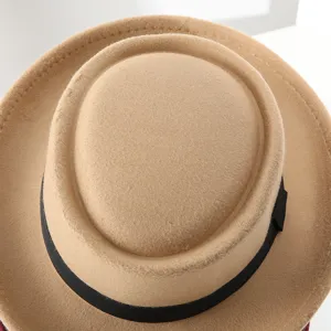 Close-up detail of khaki felt fedora hat with black ribbon, classic wool texture.