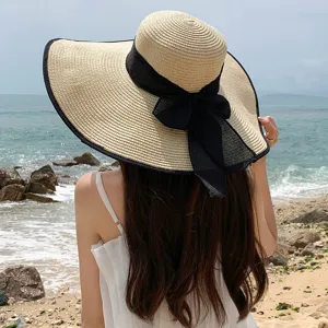Women wide brim straw hat with black bow beach sun hat summer vacation UV protection stylish.