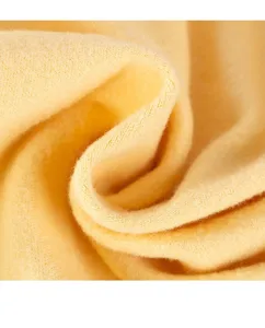 Soft yellow fleece pet clothing fabric detail close up showing warm thermal texture material.
