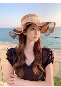 Cappello di paglia estivo da donna a tesa larga con design a onda in rete per protezione solare.