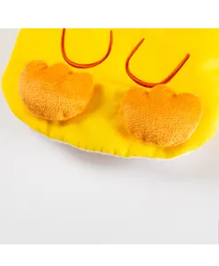 Nahaufnahme von niedlicher gelber Haustierkleidung mit Plüsch-Entenfüßen und Stickerei.