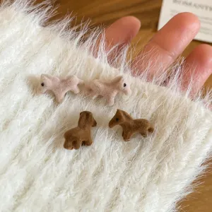 Primo piano dettagliato di mini orecchini a perno cavallo floccato con texture morbida.