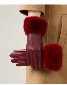 Close-up view of elegant burgundy leather gloves featuring plush red fur cuffs for winter.