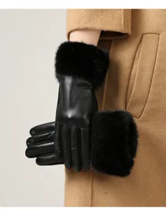 Close-up view of elegant black leather winter gloves featuring thick plush fur cuffs