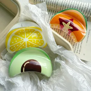 Close-up of fruit print hair claw clips featuring avocado and lemon designs