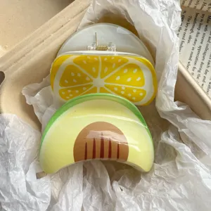 Close-up view of fruit print hair claw clips featuring avocado and lemon patterns