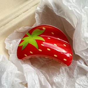 Close-up of a sweet glossy red strawberry pattern acetate hair claw clip in paper