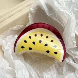 Detailed top-down view of a passion fruit print hair claw clip on white paper props