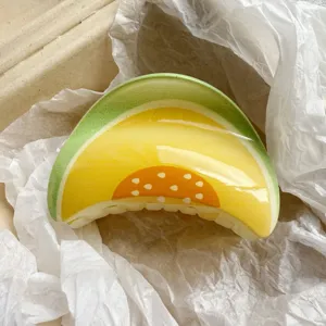 Detailed view of a vibrant glossy hair claw clip featuring a refreshing melon fruit print pattern.