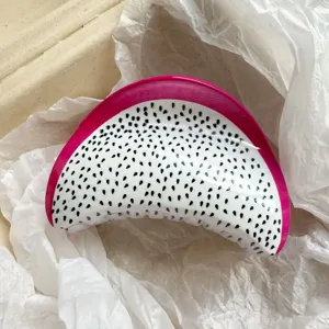 Detailed close-up showing the glossy texture of a dragon fruit slice hair claw clip.