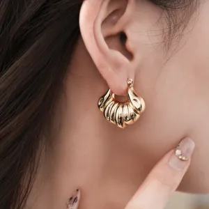 Boucles d'oreilles créoles dorées géométriques côtelées, bijoux fantaisie tendance femme.