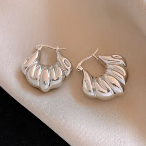 Vue détaillée de boucles d'oreilles créoles argentées épaisses et nervurées, style élégant.