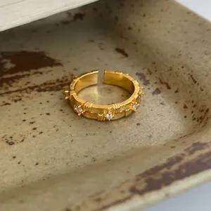 Gold plated open ring with sparkling cubic zirconia, vintage textured design for women.