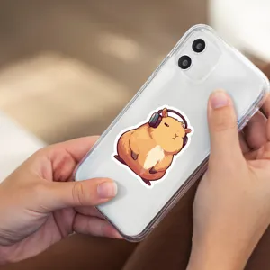 Clear phone case featuring a cute capybara with headphones sticker design for daily use.