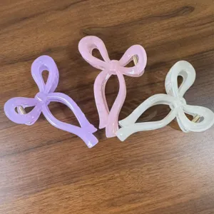Σετ τριών μινιμαλιστικών 3D κλιπ μαλλιών με φιόγκο σε παστέλ χρώματα σε ξύλινο τραπέζι