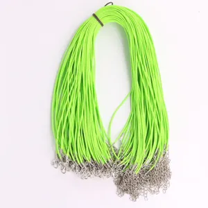 Close-up detail of vibrant neon green DIY wax necklace cords with silver clasps