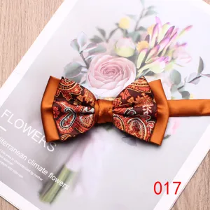 Close-up detail of a stylish orange paisley bow tie with elegant two-tone satin contrast.