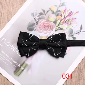 Closeup detail of black bow tie featuring elegant white geometric lines on floral background.