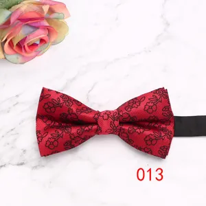 Detailed view of a red floral men's business bow tie on marble background with rose.