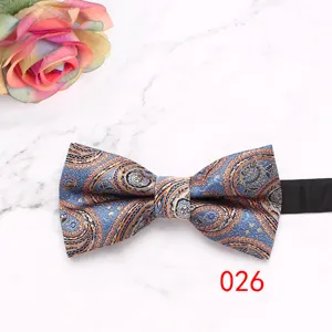 Detailed view of blue paisley pattern men's bow tie with elegant floral design texture.