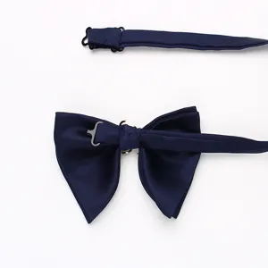 Dettaglio ravvicinato di farfallino in raso blu navy con cinturino regolabile e metallo.