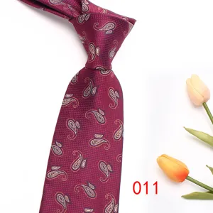 Burgundy paisley men necktie detail, elegant jacquard silk tie showcase for business suit.