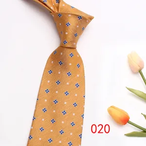 Close up of gold men tie with blue clover jacquard pattern and tulip flower prop detail.
