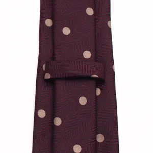 Detailed view of burgundy mens classic polka dot herringbone silk tie for business wedding.