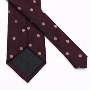 Close-up detail of burgundy mens polka dot tie showing back lining and classy fabric weave.