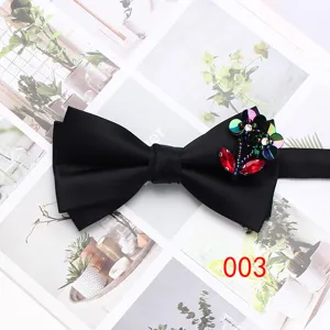 Detail view of a classic black double-layer men's bow tie with glittering rhinestone flower decor.