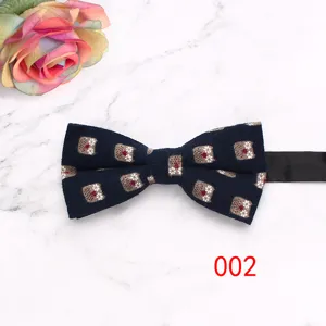 Vue détaillée du nœud papillon bleu foncé avec joli motif sur fond marbre avec rose.